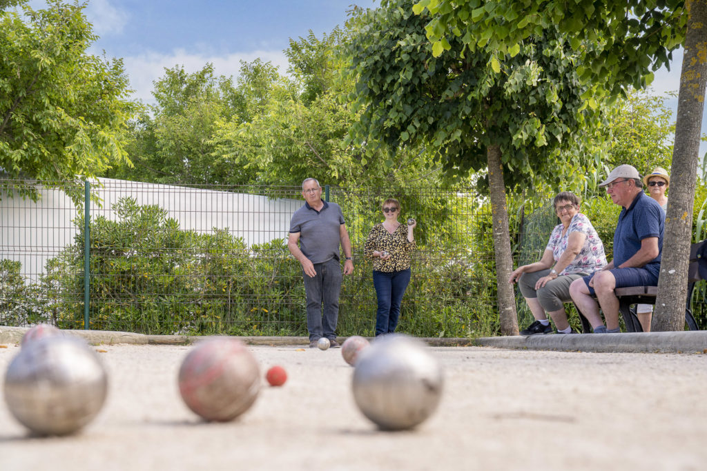 Personnes jouant à la pétanque en extérieur.