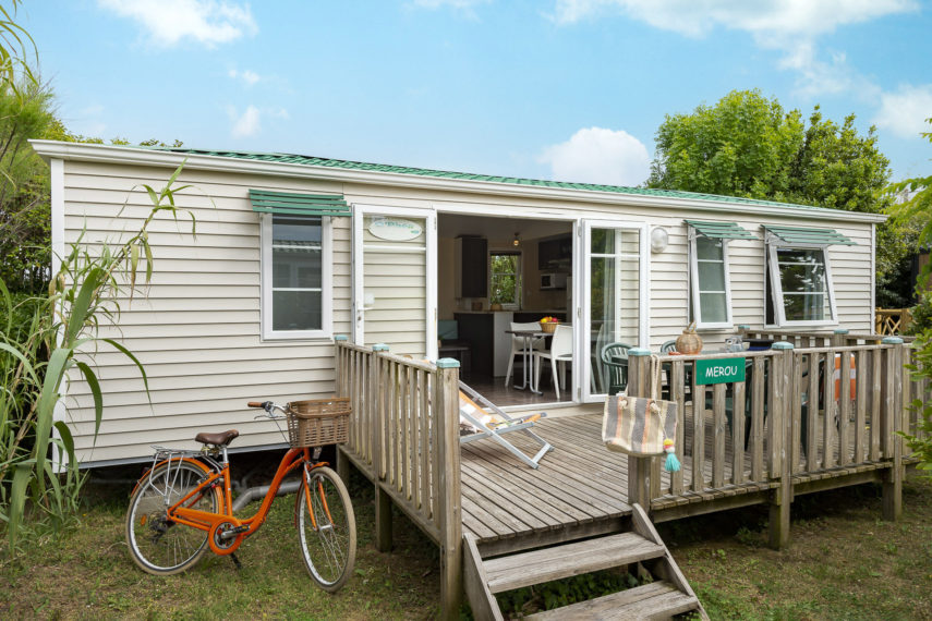 Mobil-home avec véranda en bois et vélo orange