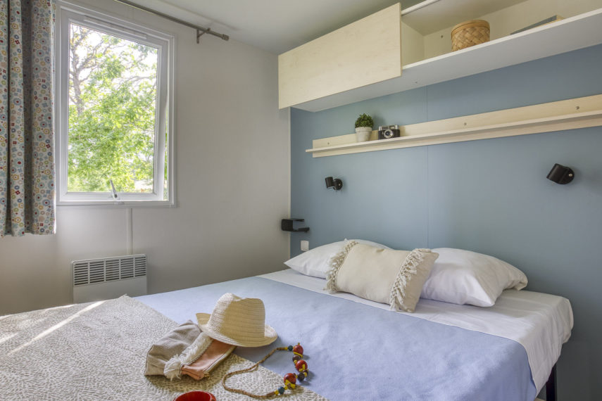 Chambre lumineuse avec lit double, accessoires de plage.