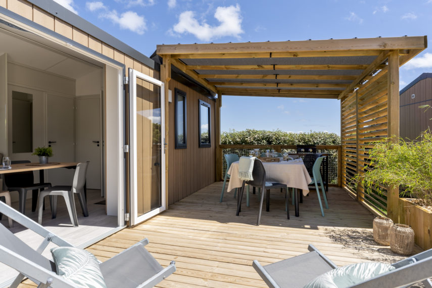 Terrasse bois avec table dressée pour repas extérieur.