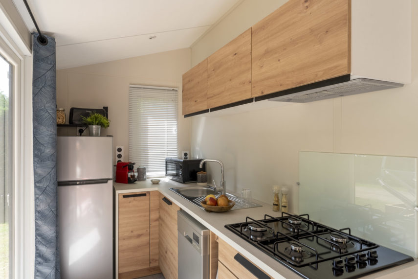 Cuisine moderne avec bois clair et inox.