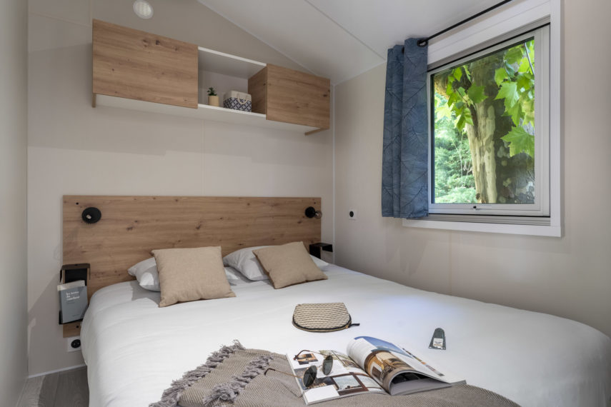 Chambre moderne avec lit double et vue sur jardin.