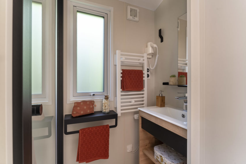 Petite salle de bain moderne avec serviettes rouges.