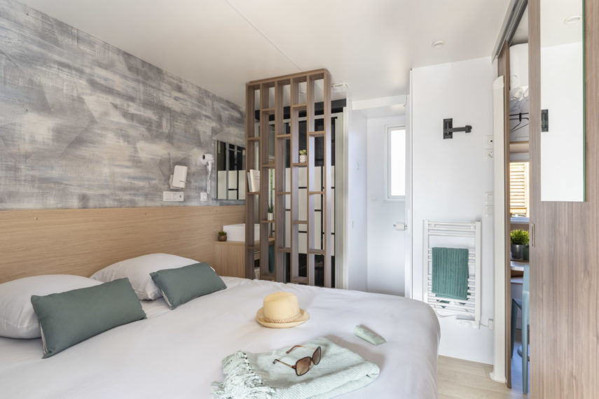 Chambre moderne avec lit et décoration apaisante.