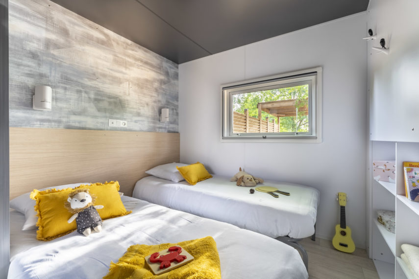 Chambre enfant moderne avec jouets et lits jumeaux