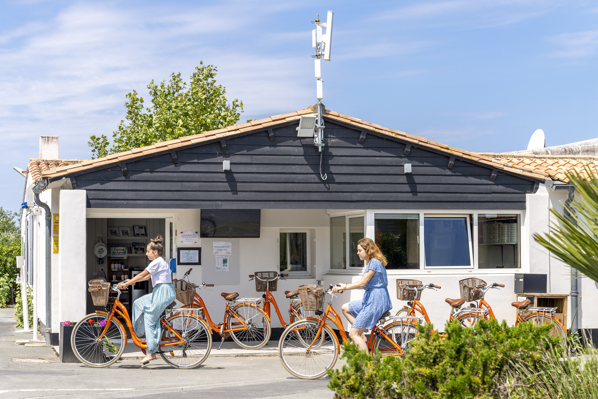Personnes à vélo devant une location.