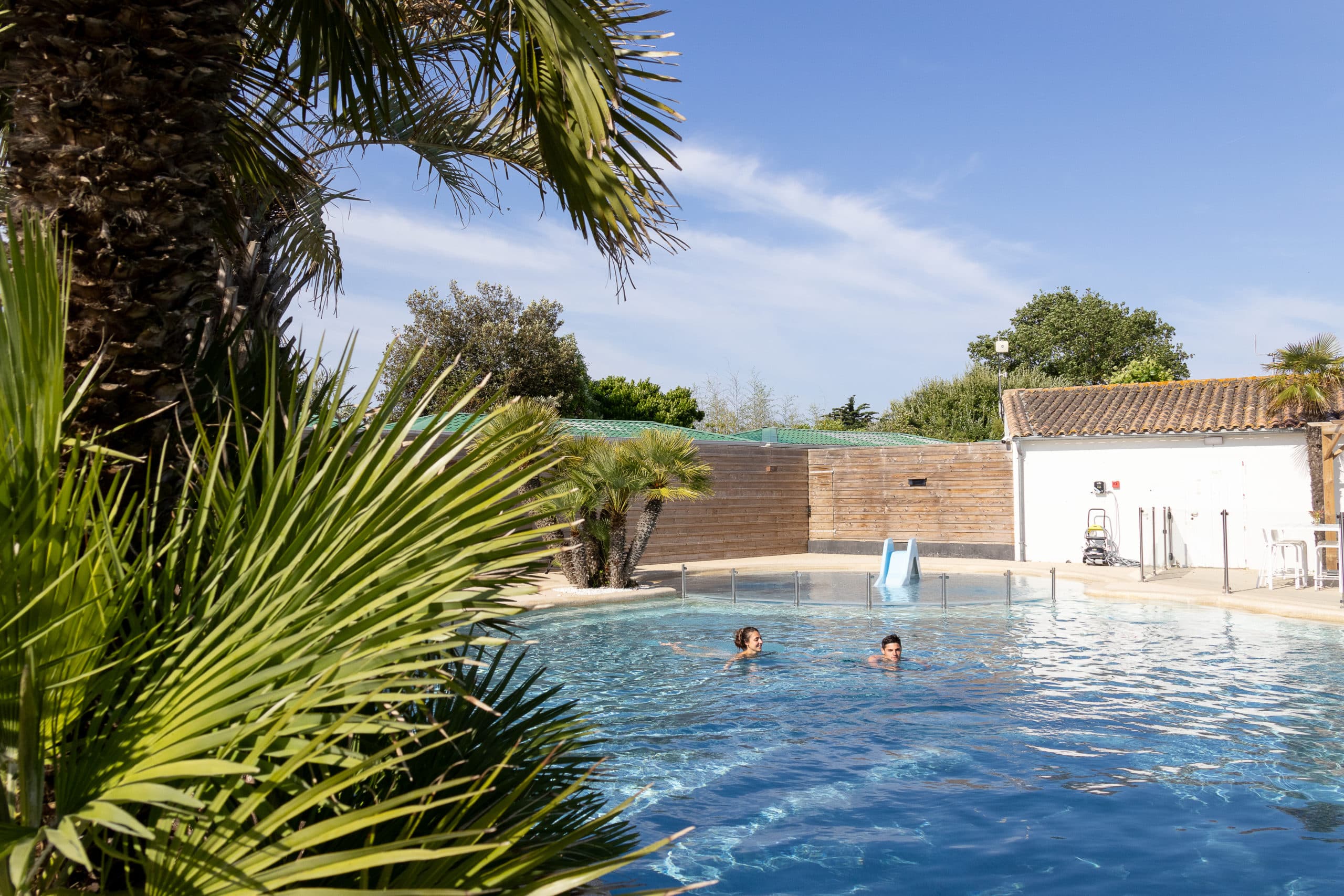 Piscine extérieure avec toboggan et palmiers