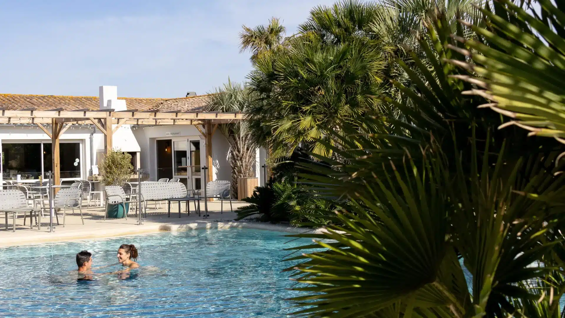 Couple nageant dans une piscine ensoleillée