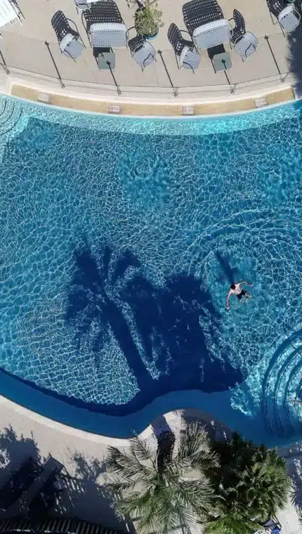 Vue aérienne d'une grande piscine ensoleillée.