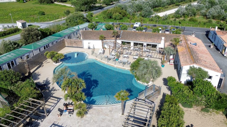 Vue aérienne piscine et restaurant avec terrasse.