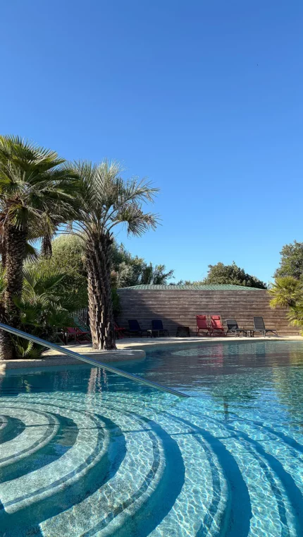 Piscine extérieure avec palmiers et ciel bleu