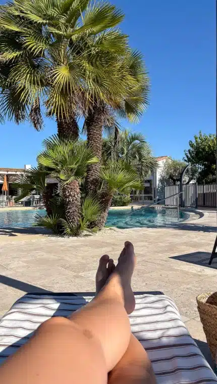 Détente au bord de la piscine sous les palmiers.